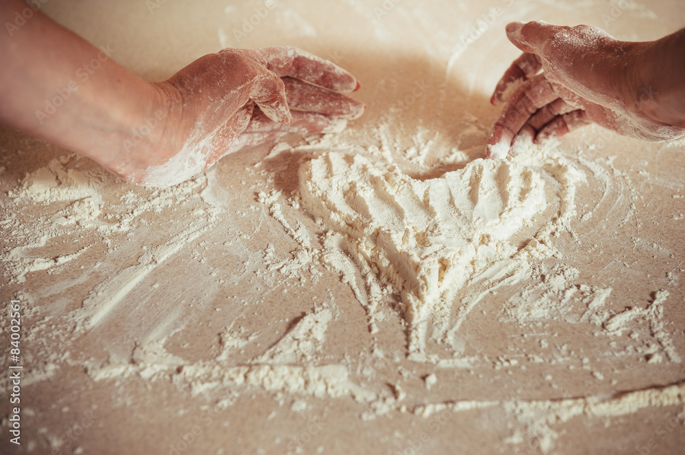 Fototapeta premium Woman holding dough heart in his hands
