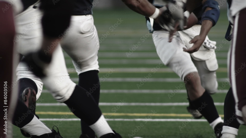 Low angle foot shot of football players running a play Low angle foot shot of football players running a play