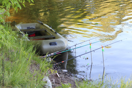 Fototapeta Naklejka Na Ścianę i Meble -  inflatable boat and fishing rods on the river