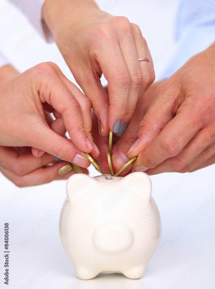 Putting coin into the piggy bank Putting coin into the piggy bank
