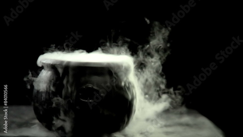 A Cauldron steams on a black background
