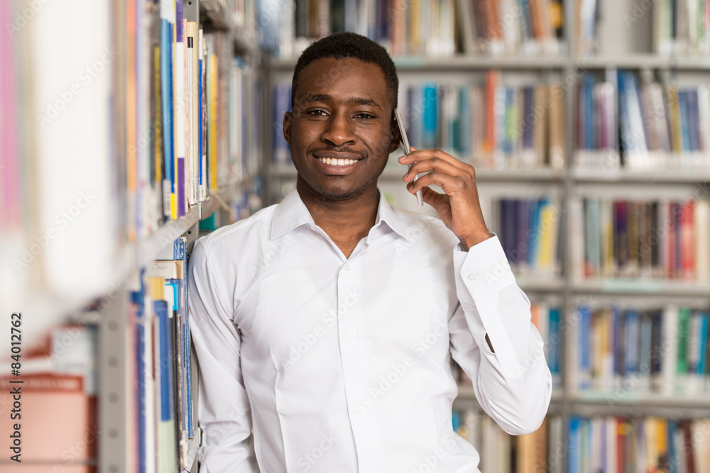 Handsome College Student Using Mobile Phone In Library Handsome College Student Using Mobile Phone In Library