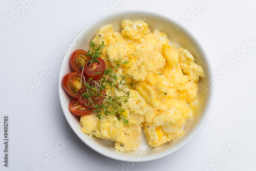 Aerial view tasty fresh scrambled eggs on plate white background