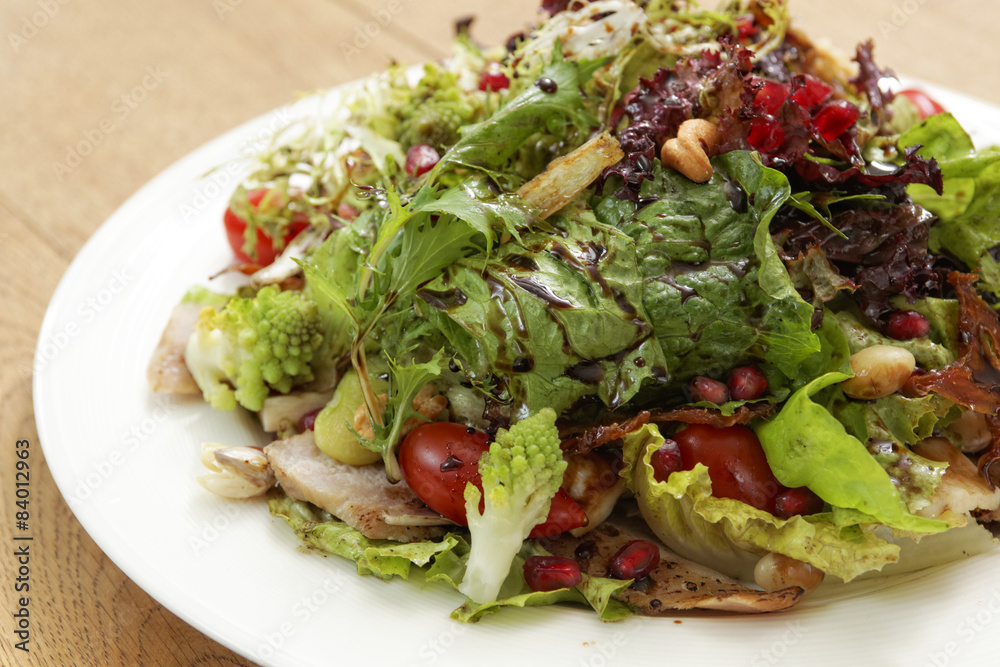 one dish of salad on wood table one dish of salad on wood table