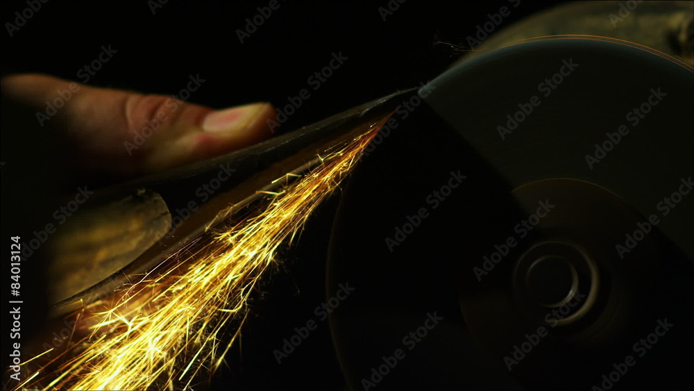 A tool being sharpened on a grinder