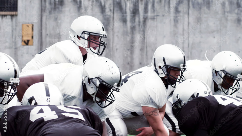 A Football team protects the Quarterback as he passes the ball. Slow motion.