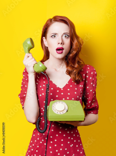 girl in red dress with green dial phone