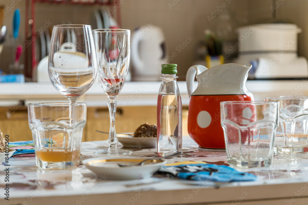 Empty glasses on the table after a good lunch at home in the kitchen Empty glasses on the table after a good lunch at home in the kitchen