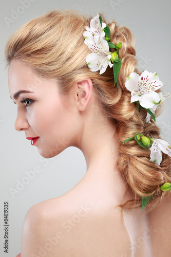 Beautiful girl with varicoloured flowers in hairs
