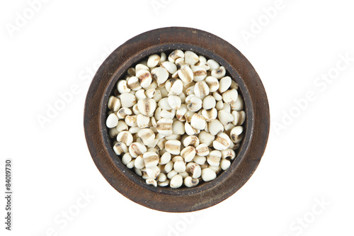 Millet in wood bowl on isolated white