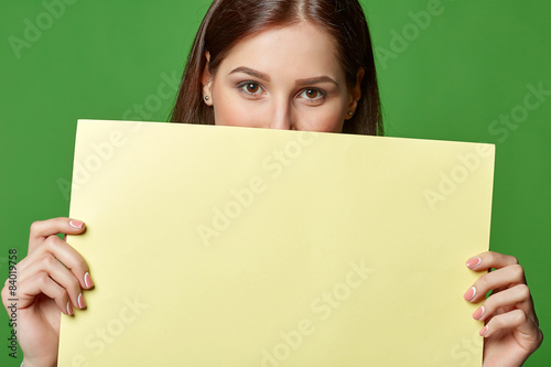 Young beautiful woman, holding yellow blank advertising board 
