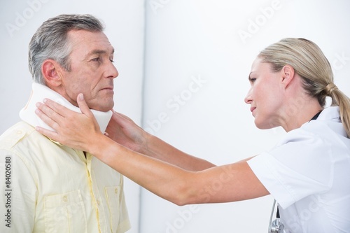 Doctor examining patient wearing neck brace