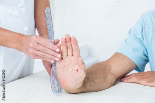  Doctor measuring wrist with goniometer  photo