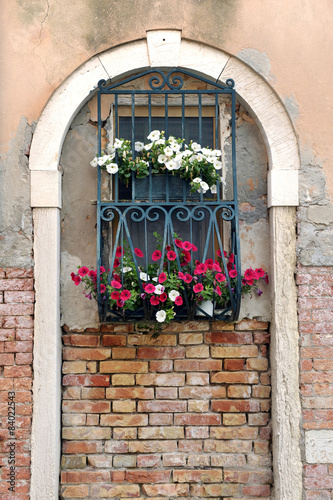 Window in Arch with Iron Bars and Flower Boxes