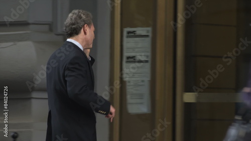 Wallpaper Mural A businessman is already working via a cell phone when he gets to his building Torontodigital.ca