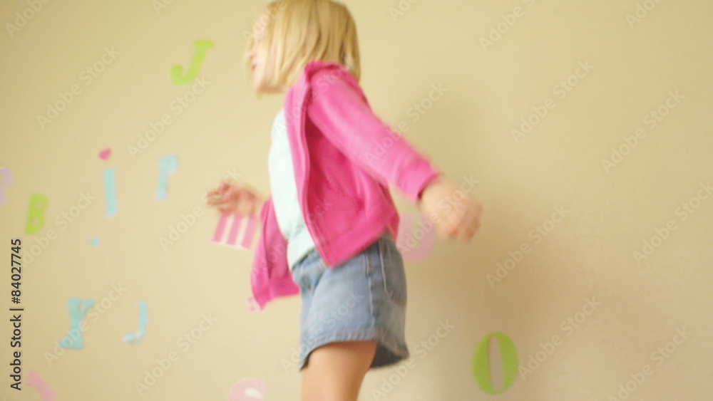 A young girl jumps up and down on her bed. With her shoes on!