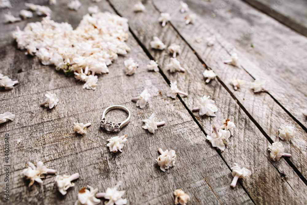 gentle white heart shape flowers with ring on wood table gentle white heart shape flowers with ring on wood table