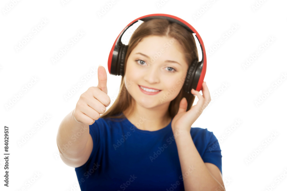 Woman with headphones and thumbs up.