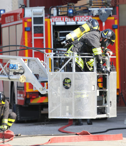 Firefighter on cage of fire ladder