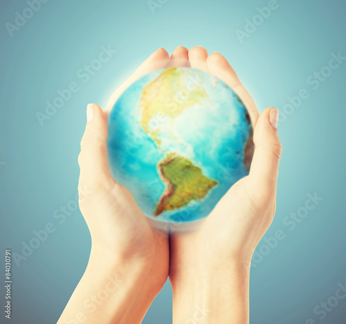 close up of human hands with earth globe