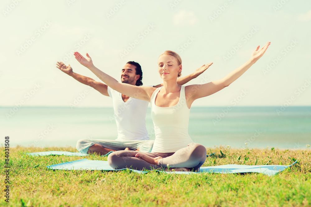 smiling couple making yoga exercises outdoors smiling couple making yoga exercises outdoors