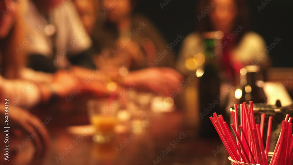 The camera focuses in front of all the people as they go about drinking together