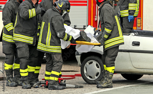 wounded person carried by firefighters on a stretcher