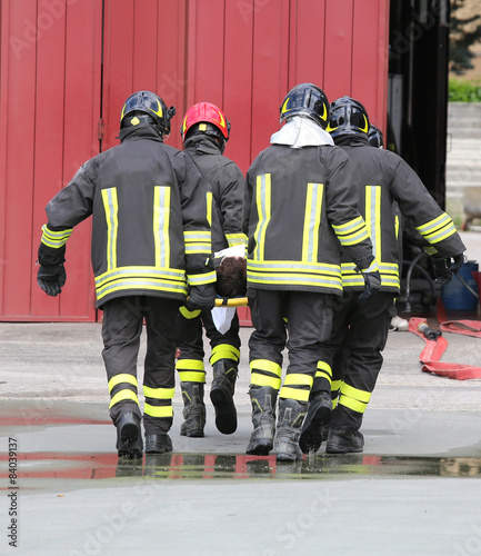 wounded carried by firefighters on a stretcher