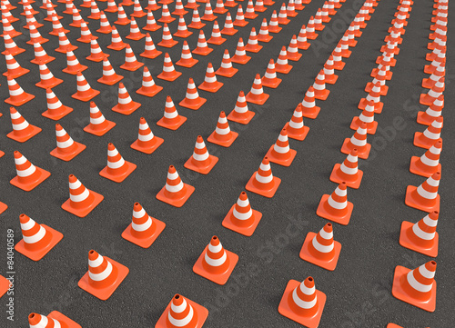 hundreds of traffic cones arranged in a row on the asphalt
