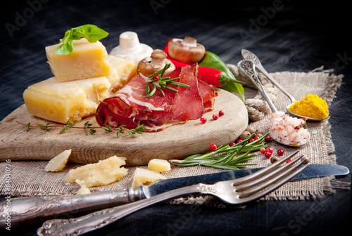 Various cheeses, salami and mushrooms on the wooden board photo