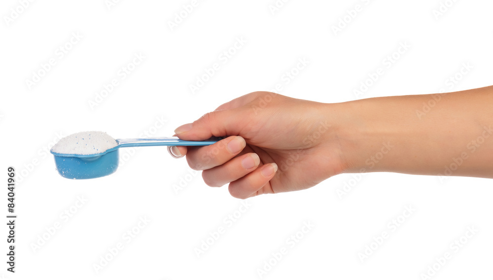 Measuring cup with washing powder in hand Measuring cup with washing powder in hand