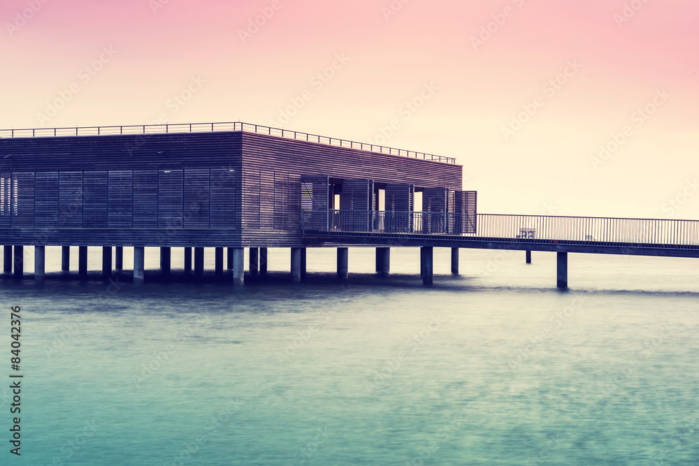 The wooden building on stilts over Lake Constance at dusk.