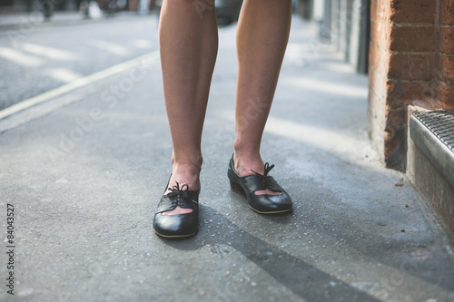 Legs of woman standing on the pavement