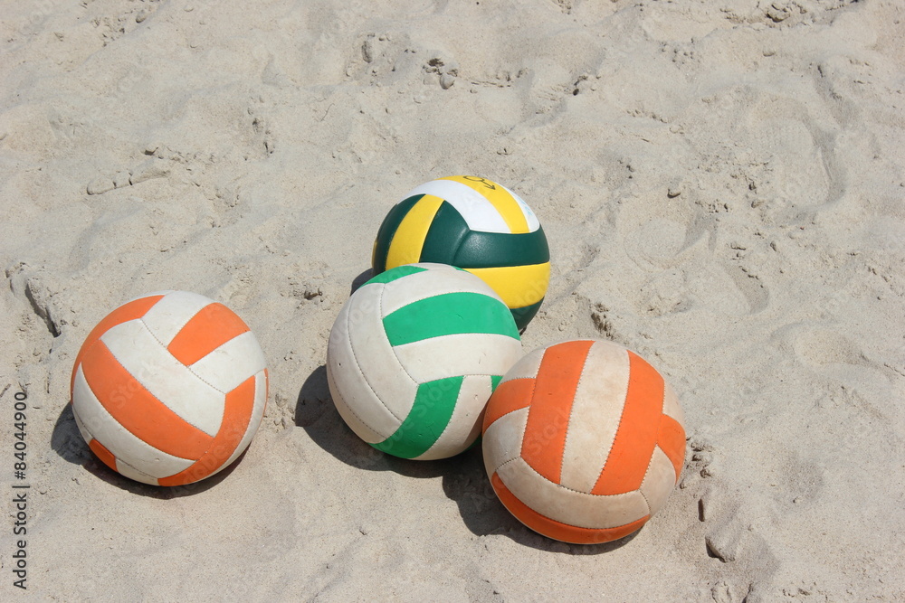 Vier Bälle für Volleyball auf einem Sandplatz
