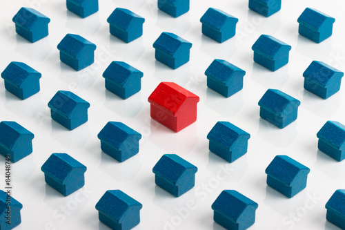 Large red house in group of smaller blue houses.
