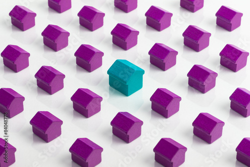 Large blue house in group of smaller purple houses