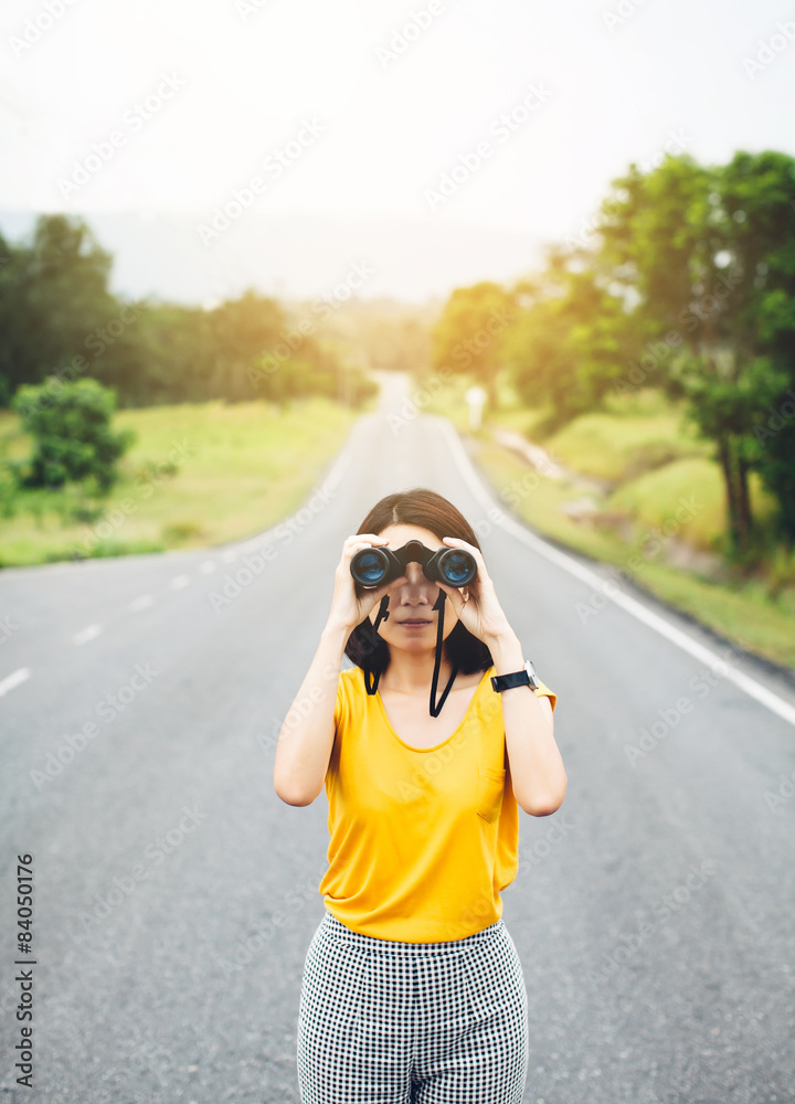 Women and binoculars in hands, with focus on a binocular