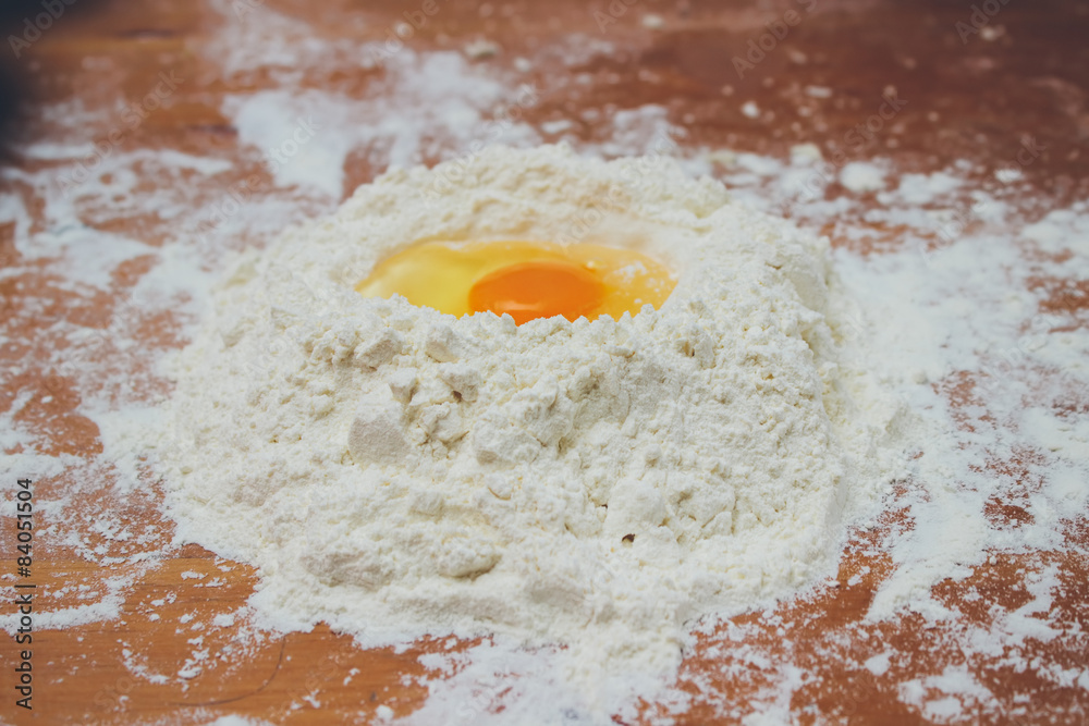 Food ingredients: egg yolk on a flour staple. Retro colors Food ingredients: egg yolk on a flour staple. Retro colors