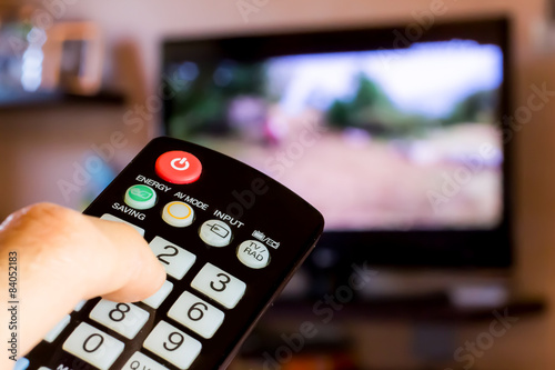 Konstfotografi using the remote control to change channesl on Tv