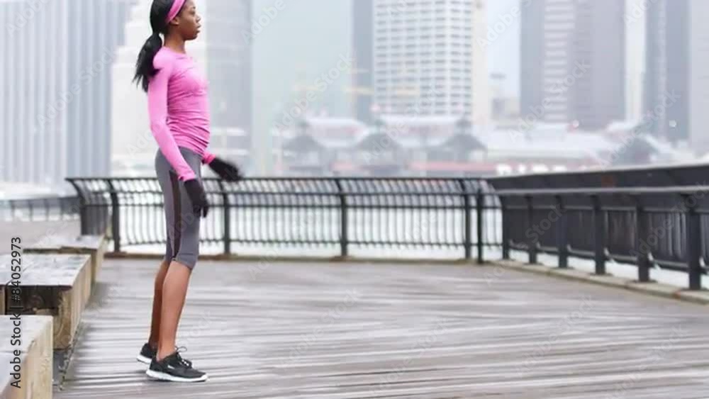 A woman gets loose and warms up before a run in brooklyn, in the rain A woman gets loose and warms up before a run in brooklyn, in the rain