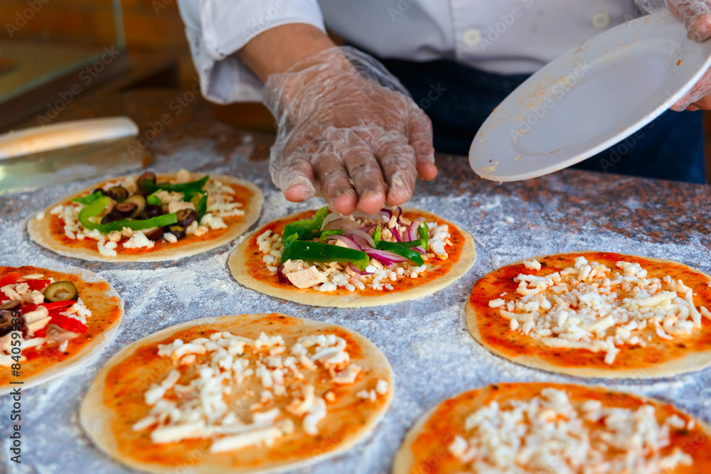 The chef, who puts toppings on a pizza