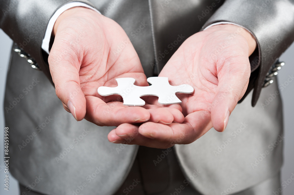 Fototapeta premium businessman show white jigsaw in hand, business strategy concept