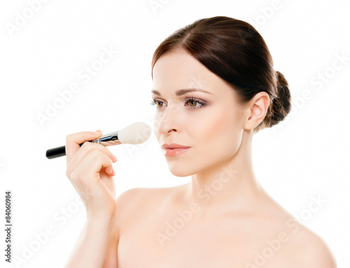 Beauty portrait of young woman holding makeup brushes