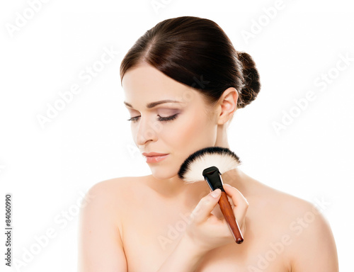 Fotografie Beauty portrait of young woman holding makeup brushes