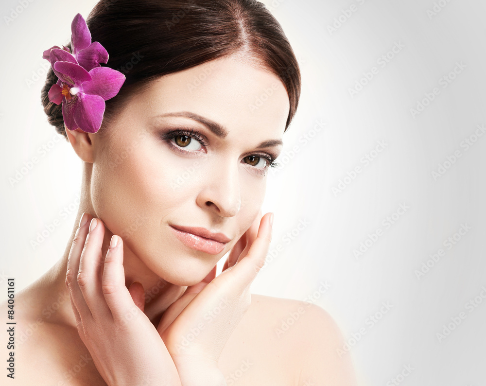 Beautiful face of a young and healthy girl with an orchid flower Beautiful face of a young and healthy girl with an orchid flower