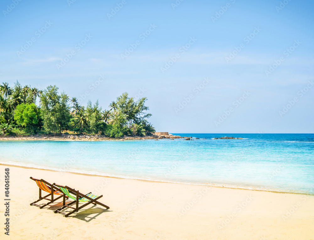 Lounge chairs on a tropical beach at summer