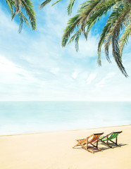Lounge chairs on a tropical beach at summer