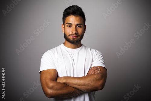Joven latino con barba y brazos cruzados photo