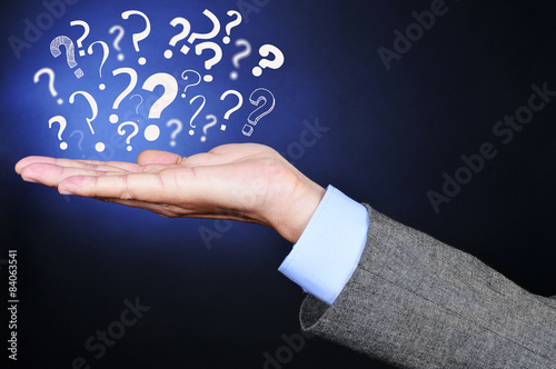 Canvas Print question marks on the hand of a young man