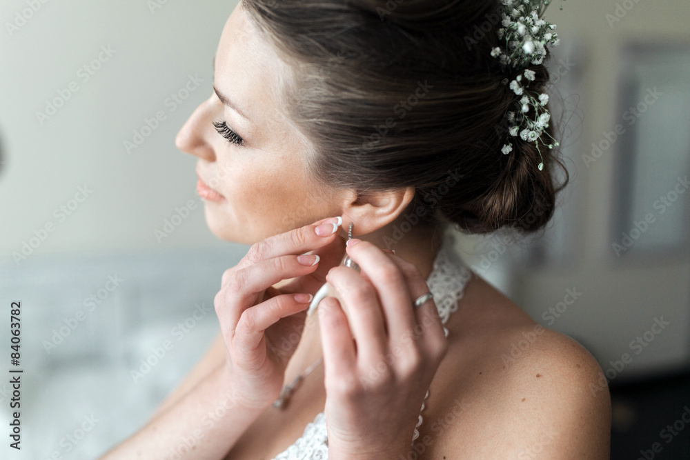 Bride puts on earrings